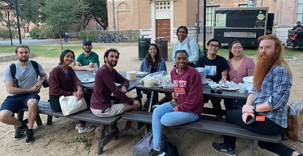 psycgsa students enjoying food and drinks outside picnic table